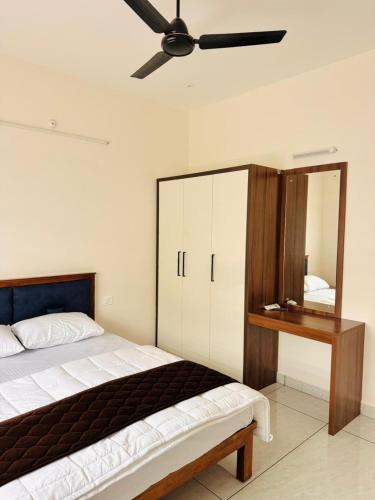a bedroom with a bed and a ceiling fan at JK Homes in Alwaye