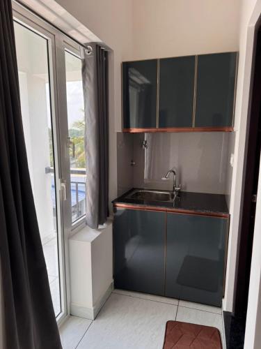 a small kitchen with a sink and a window at JK Homes in Alwaye