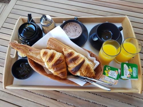 a tray of food with bread and drinks and orange juice at les terrasses d'arutoli in Porto-Vecchio