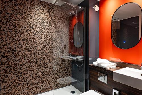 a bathroom with a shower and a sink and a mirror at Village Hotel Birmingham Walsall in Walsall