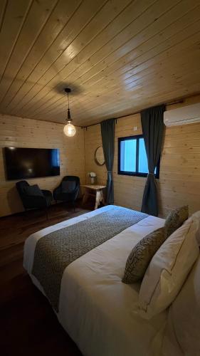 a bedroom with a large white bed in a room at פינה בראש מלונאות ותיירות in Rosh Pinna