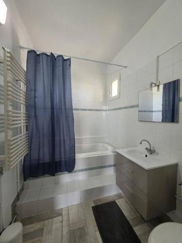 a bathroom with a tub and a toilet and a sink at Cocon urbain avec jardin - appartement proche hôpital in Angers