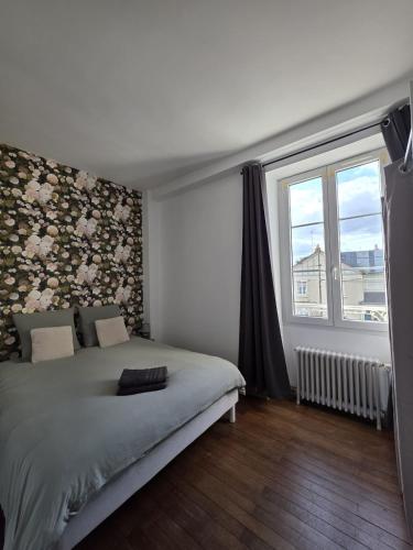 a bedroom with a bed with a floral wall at Cocon urbain avec jardin - appartement proche hôpital in Angers