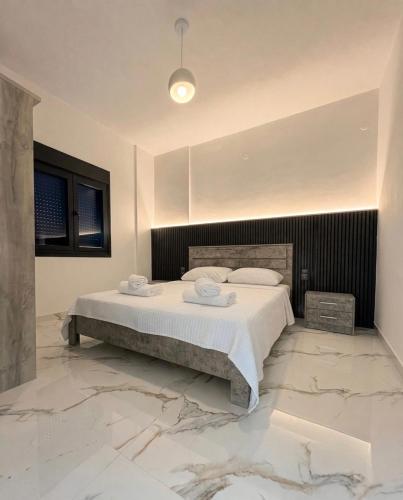 a bedroom with a large bed with marble floors at Mirage Luxury Living in Nea Potidaea