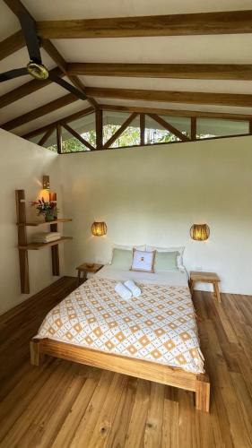 a bedroom with a large bed with two pillows at Casa Yami Lodge in Fortuna