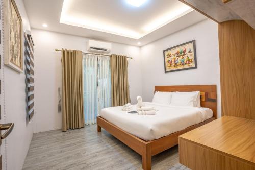 a bedroom with a bed and a desk in a room at La Patria Chica in Sampong
