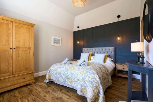 a bedroom with a bed and a dresser and a table at Host & Stay - Mole Cottage in Swannington