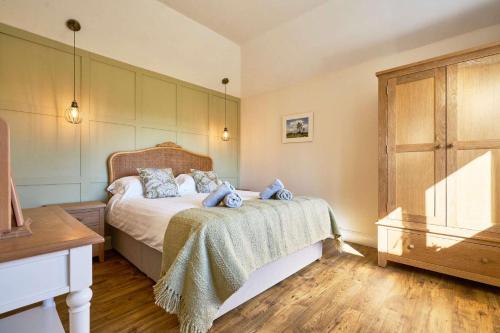 a bedroom with a bed and a wooden floor at Host & Stay - Toad Cottage in Swannington