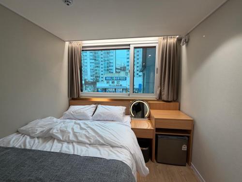 a bedroom with a bed and a desk with a window at Sonoće Hostel Seoul - Private Bathroom & Premium in Seoul