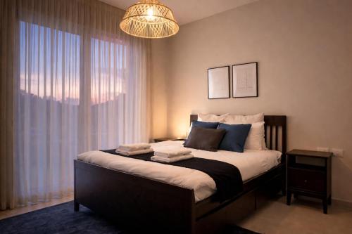 a bedroom with a large bed with a chandelier at וילת האושר אילת in Eilat