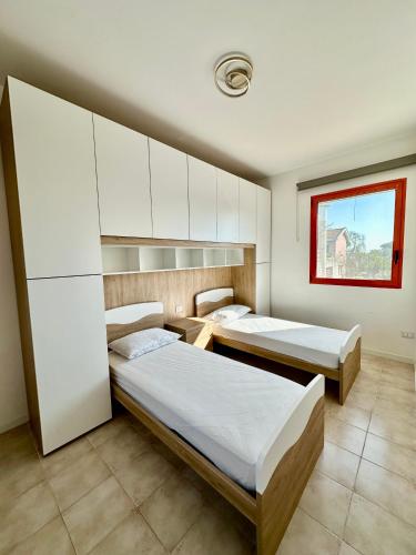 a bedroom with two beds and a window at Solleone 18 - Sea, Sun e Pool in Cavallino-Treporti