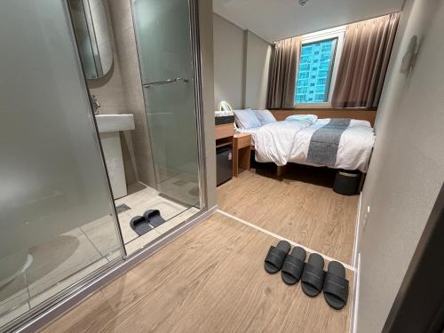 a bedroom with a bed and a shower and shoes at Sonoće Hostel Seoul - Private Bathroom & Premium in Seoul