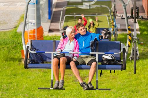 a man and woman sitting on a ski lift at Casa di vacanza Giovanibosco in Bosco Gurin