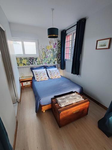 a small bedroom with a bed and a table at Studio Augustine, studio pour une pause en Baie du Mont Saint Michel in Roz-sur-Couesnon
