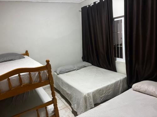 a bedroom with two beds and a window at Casa 100mtrs do mar com piscina aquecida in Solemar