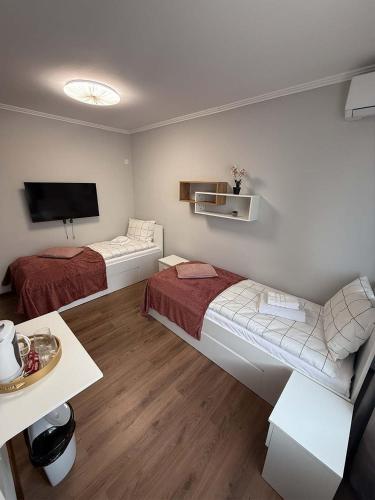 a small room with two beds and a tv at Eclipse grill and pizza in Corunca