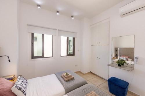 a white bedroom with a bed and a mirror at Villa Mylos 7 in Protaras