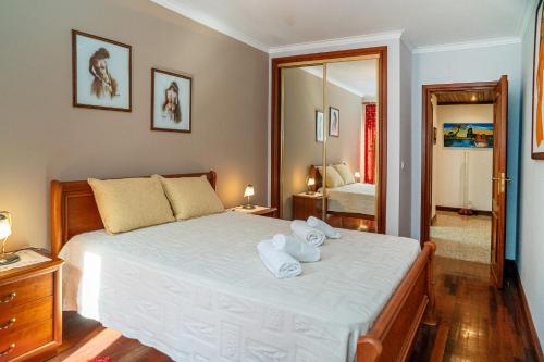 a bedroom with a bed with towels on it at Brisa de Sesimbra - Spacious Family Apartment, 5min Walk to the Beach with Private Parking in Sesimbra