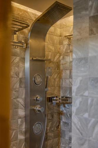 a shower in a bathroom with a stone wall at Blue Sea Explorer in Male City
