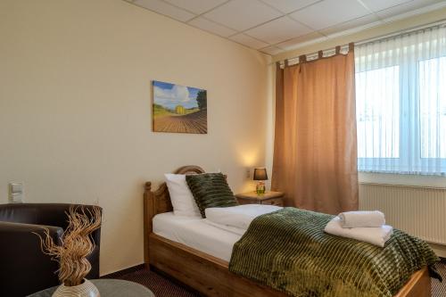 a bedroom with a bed and a window at Hotel Schöne Altmark in Kalbe