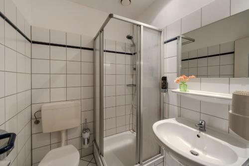 a bathroom with a shower and a toilet and a sink at Hotel Schöne Altmark in Kalbe