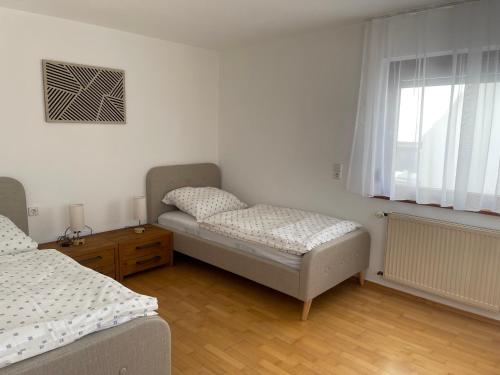 a bedroom with two beds and a window at Gästeapartment in ruhiger Lage in Rainau