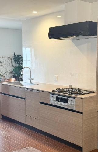 a kitchen with a sink and a stove top oven at Pavilion Beachfront in Shishikui
