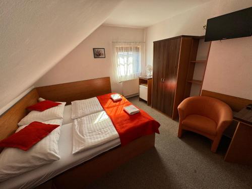 a hotel room with a bed and a chair at Pension Euro in Mikulov