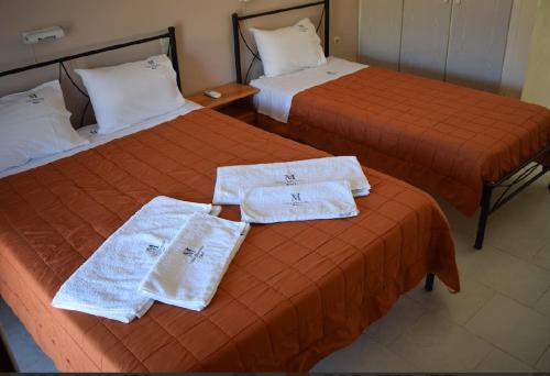 two beds in a hotel room with towels on them at Villa Miranda in Keri