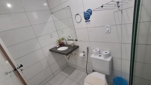 a white bathroom with a toilet and a sink at Pousada Maresia in São Miguel dos Milagres
