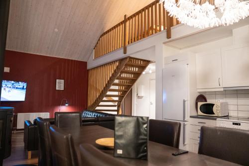 a dining room with a table and a staircase at Hovfjällstoppens Stugby in Överbyn
