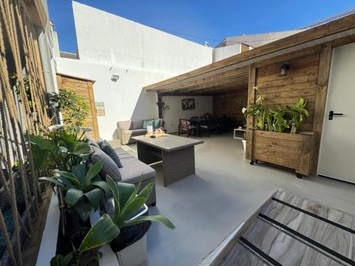 a patio with plants and a table on a building at Costa Paradise Beach in Costa da Caparica