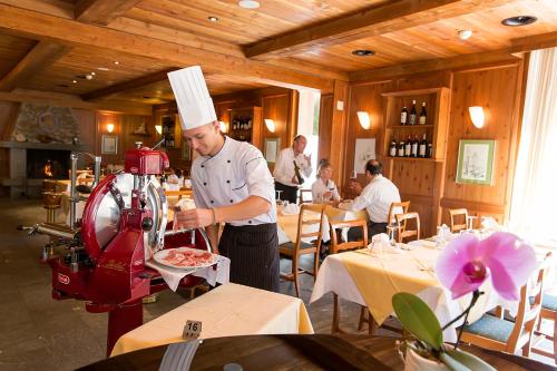a chef is preparing food in a restaurant at Casa di vacanza Giovanibosco in Bosco Gurin