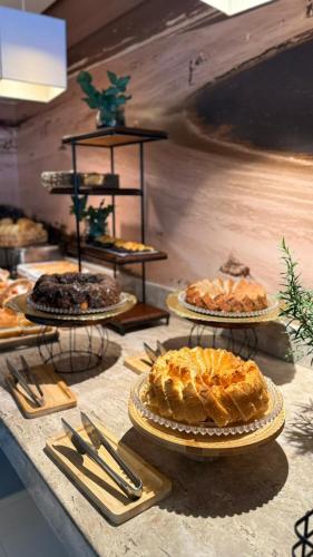 a table with several plates of pies on it at Linhares Design Hotel in Linhares