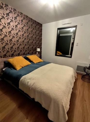 a bedroom with a large bed and a mirror at Kercabellec entre mer et marais in Mesquer