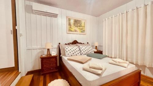 a bedroom with a bed with two pillows on it at Casa Próximo ao Centro e Hospital in Blumenau