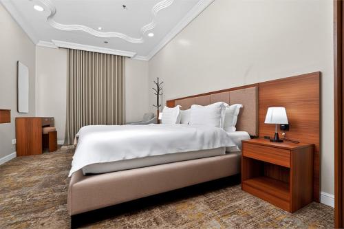 a large bedroom with a large bed and a night stand at فندق دارك بارك حي الشاطئ Darak Park Hotel Jeddah in Jeddah