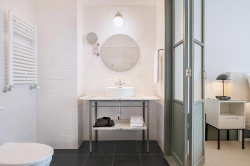 a bathroom with a sink and a mirror at Rosário Suites Townhouse in Porto