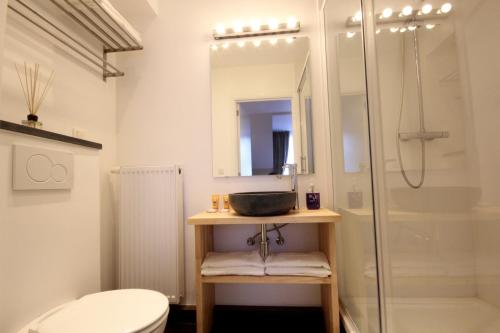 a bathroom with a shower and a sink and a toilet at Hooome in Brussels