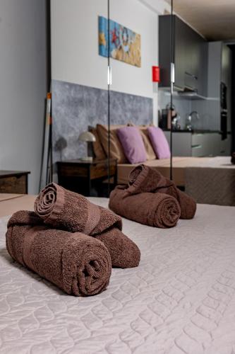 a group of towels sitting on top of a bed at Seafront, lovely modern studio. in St. Julianʼs