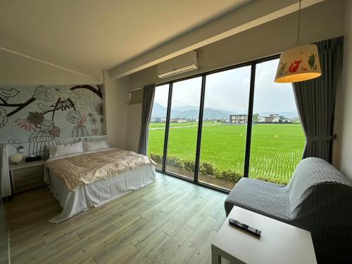 a bedroom with a bed and a large window at Lan Yang Resort Four Seasons in Dongshan