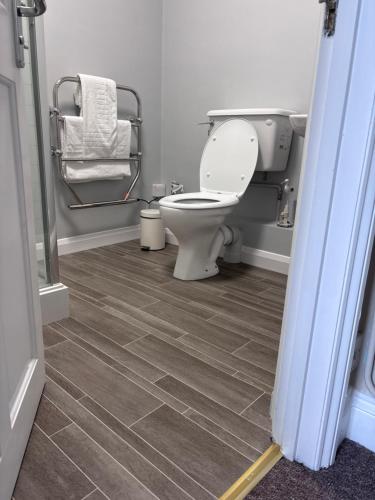 a bathroom with a toilet and a tile floor at Fleur De Lis Hotel in Sandwich