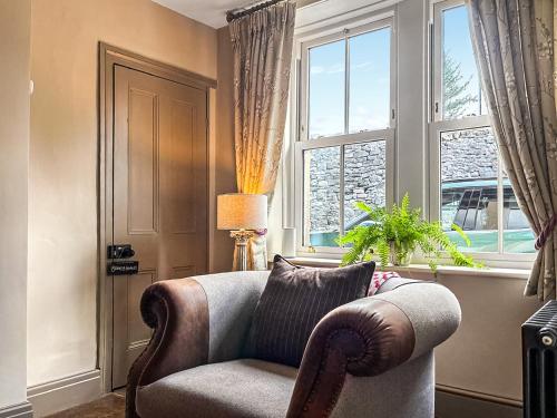 a living room with a chair and a window at Jasmine Cottage in Grassington