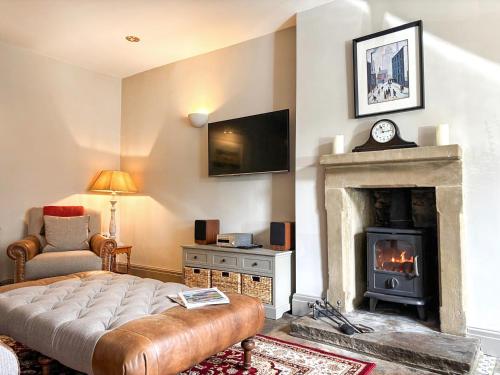 a living room with a fireplace and a television at Jasmine Cottage in Grassington