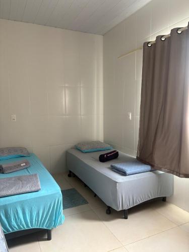 a room with two beds in a room at Casa charmosa familiar in Chapada dos Guimarães