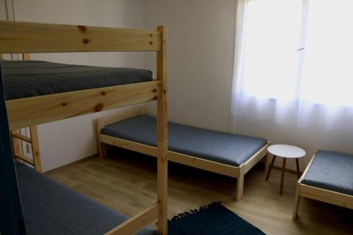 two bunk beds in a room with a table and a stool at DrótSzarvas Üdülőház in Bogács