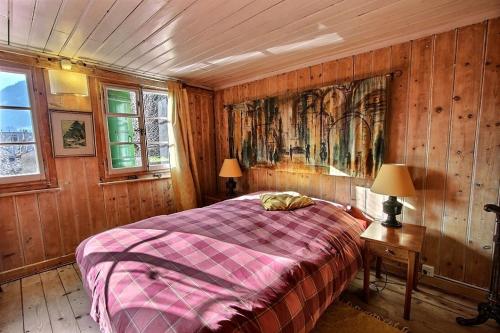 a bedroom with a bed and a painting on the wall at Chalet Vallonette in Chateau-d'Oex
