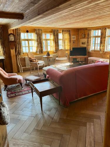 a large living room with a couch and chairs at Chalet Vallonette in Chateau-d'Oex