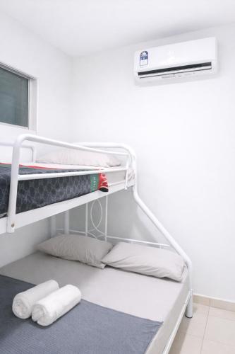 a white room with a bunk bed with two pillows at JAA Homes 1-8 Pax Family Stay Jalan UMS KK in Kota Kinabalu