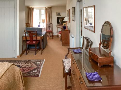 a living room with a table and a mirror at Stepping Gate Cottage in Scalby